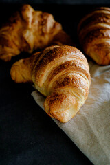 Delicious breakfast with fresh and baked french croissants on a dark concrete background