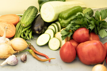 Fresh vegetables on a gray cement background Zucchini Tomatoes Cucumbers Carrots Potatoes String Beans Onion Garlic Celery Healthy Food Copy Space Agriculture