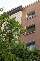 Facades of urban residential buildings with gardens and lots of trees