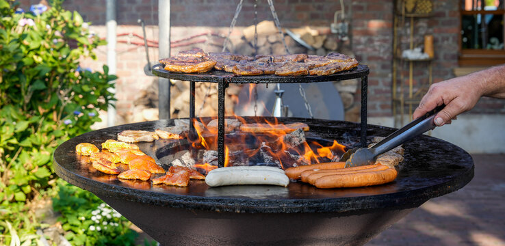 Großer BBQ Grill mit Flammen und Steak und Bratwürste 