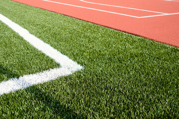 Sports stadium background. Red artificial rubber court ground and white line and green synthetic...
