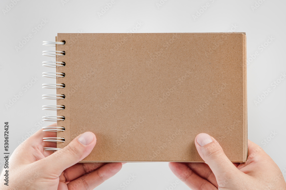 Wall mural notepad in hand. blank notepad in the hands of a man on a white background. hands hold a book withou