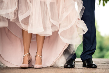 beautiful legs of a girl in shoes stand next to the legs of a man in trousers