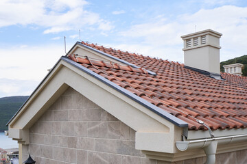 Roof made of modern polymer roofing shingles against the blue sky