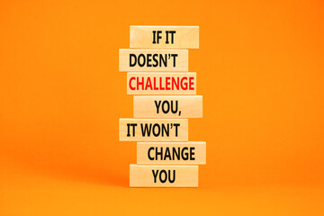 Challenge to change symbol. Concept words If it does not challenge you it wont change you on blocks on a beautiful orange table orange background. Business motivational and challenge concept.