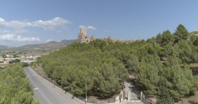 Fortaleza medieval sobre risco elevado encima de pueblo mediterr&aacute;neo a vista de dron