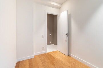 Empty room with laminate flooring and newly painted white walls. Repair and construction concept.