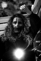 Young woman in halloween makeup with a roman candle at night. Close up of a woman wearing halloween makeup at night