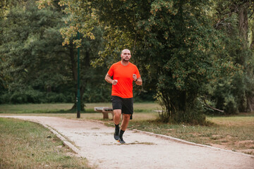 Fototapeta premium Athletic young man running in nature. Healthy lifestyle