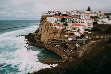 Fototapeta na wymiar View to Azenhas do Mar rocky beach and village in Colares, Portugal. Tilt-shift effect