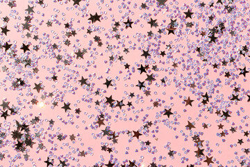 Silver stars and crystals confetti on a pink background. Glowing backdrop.