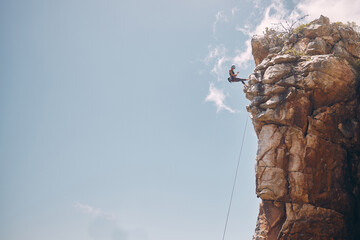 Mockup blue sky, mountain climbing woman and rock wall fearless hiking on abseiling training rope...