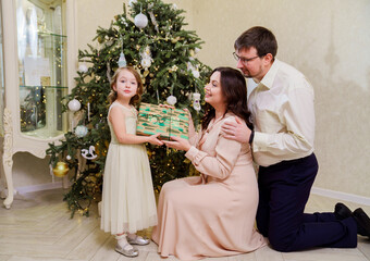 happy family with box of gift by Christmas tree. tradition giving gifts
