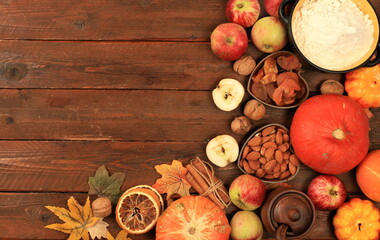 Kitchen background with pumpkin, apples, spices, nuts, flour, eggs with place for menu, cooking concept, ingredients for pumpkin and apple pies recipe, selective focus, top view