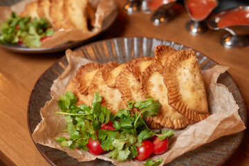 hot homemade pasties on a wooden board copy space.