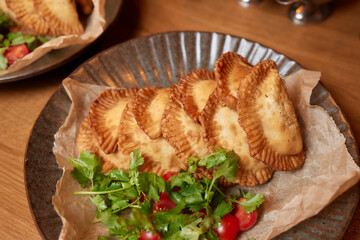 hot homemade pasties on a wooden board copy space.