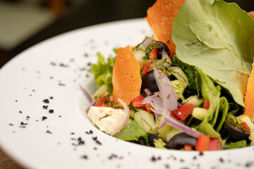salads on a white plate with a light wood background