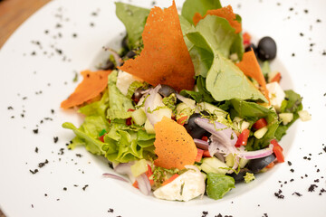 salads on a white plate with a light wood background