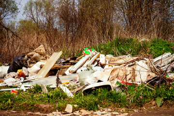 Household garbage in nature. Human pollution of the environment. People illegally throw garbage into forest. Illegal garbage dump in nature. Dirty environment garbage polluting 