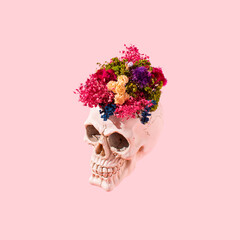 Fototapeta Abstract idea made of skull with colorful dry flowers on pastel pink background. Halloween skull or day of the dead concept. obraz