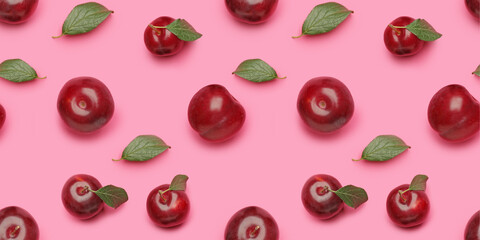 Many ripe plums on pink background. Pattern for design