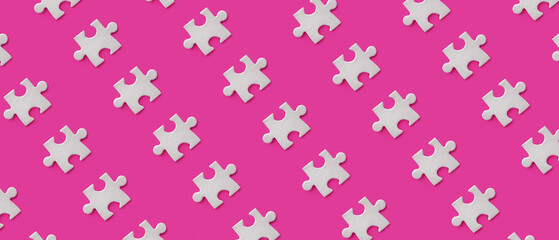 Many pieces of jigsaw puzzle on pink background. Pattern for design