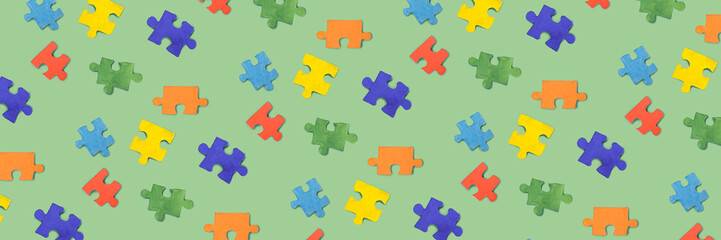 Many pieces of jigsaw puzzle on green background. Pattern for design