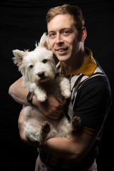 Young man holding his West Highland White Terrier