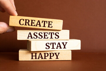 Obraz premium Wooden blocks with words 'Create Assets Stay Happy'.