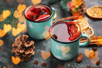 Metal mugs of delicious mulled wine on grey table