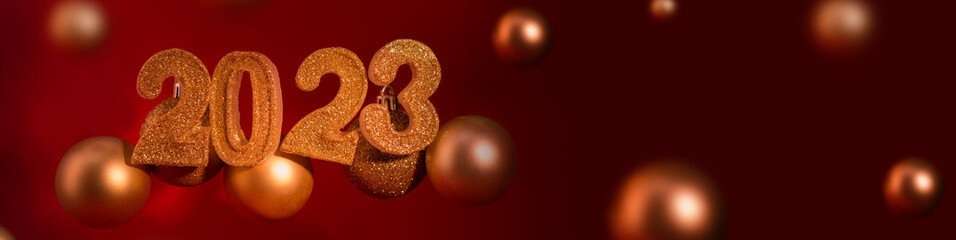 Banner with Number 2023 and Christmas balls against red background.