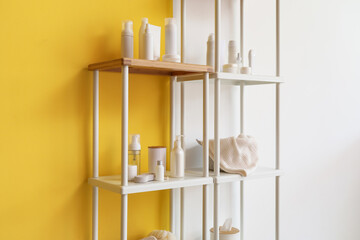 Shelf units with different bath accessories near color wall