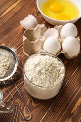 Glass bowl of flour on wooden table