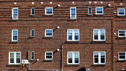 Rows of windows in a red brick wall
