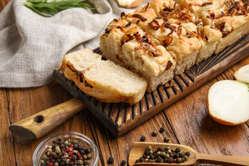 Board with delicious Italian focaccia on table, closeup