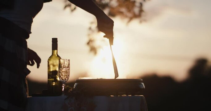 Female cook stirs risotto spatula in hand sunset close up sun flares