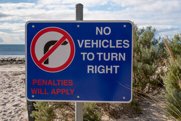 Road sign on the sea beach No Vehicles to turn right Penalties will apply Australia