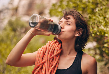 Water bottle, hiking and exercise with woman feeling thirsty and staying hydrated during fitness...
