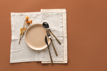 Table setting with dry roses on brown background