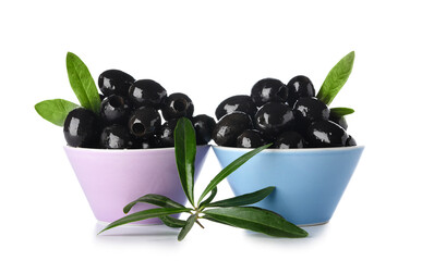 Bowls of tasty black olives on white background