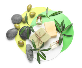 Composition with bottles of olive essential oil, soap and spa stones on white background