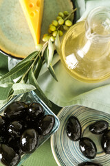 Bowl of tasty black olives and oil on table, closeup
