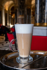 Glass cup of coffee latte served in classic old Austrian café-restaurant in Vienna