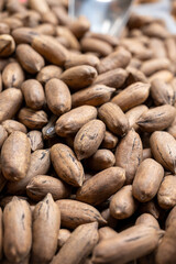 Obraz premium Roasted unpeeled pecan nuts, tasty healthy vegetarian food