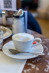 Lifestyle of Vienna, cup of hot cappuccino coffee with cream foam served in old  Viennese-style Austrian cafe