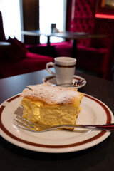 Austrian sweet dessert, filled with white cheese strudel served warm in traditional cafe in Vienna, Austria with cup of black coffee