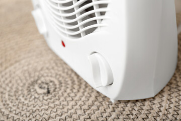 Electric fan heater on rug, closeup