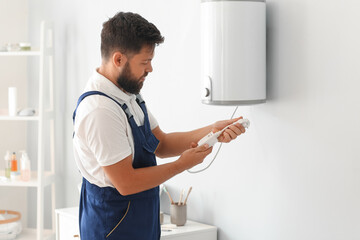 Male plumber with boiler's plug in bathroom