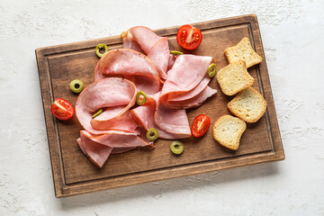 Wooden board with tasty ham on light background