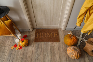 Door mat with Halloween pumpkins in hall